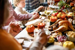 family prays around Thanksgiving table