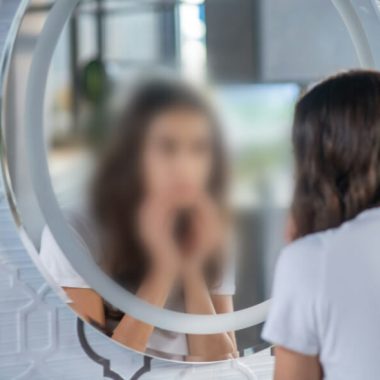 woman looking in mirror. In grief and loss of identity, Who am I after loss? is a central question. While roles change, knowing our identity in Christ secures us.